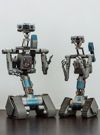 Miniature Johnny Five prop from "Short Circuit 2" & Robot V. The latter was designed by Mike Van Plew & produced by Joz Robotics.